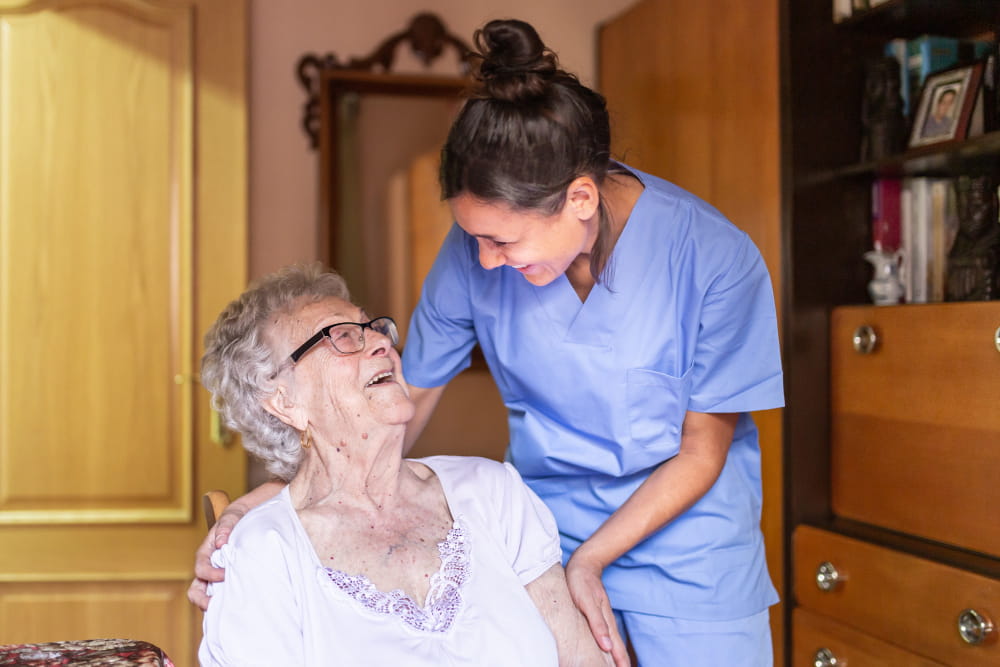 A carer supporting an older woman with overnight care